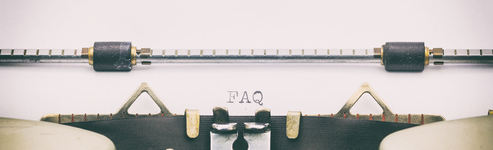 Top of a typewriter with 'FAQ' typed out in the center of the page