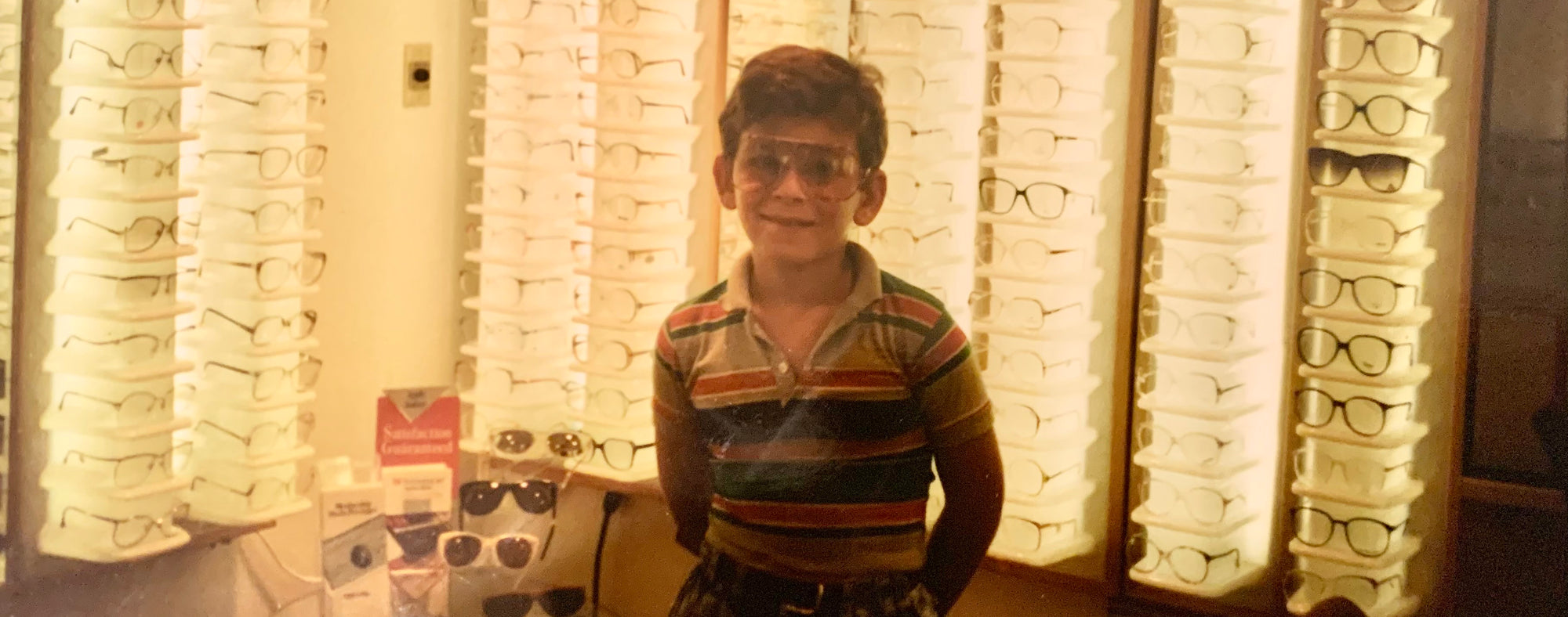 Older Photo of young boy wearing Alexander Daas Sunglasses in Retail Store